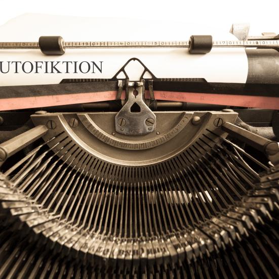 Billedet er et supernærbillede af en gammeldags skrivemaskine, hvor teksten på papiret lyder: Autofiktion